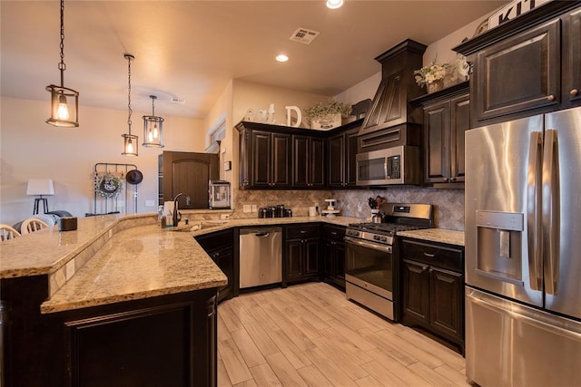9908 SW 22nd St, Yukon, OK 73099 - kitchen featuring appliances with stainless steel finishes, a sink, backsplash, light stone counters, and light wood finished floors