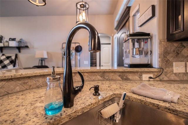 9908 SW 22nd St, Yukon, OK 73099 - kitchen view of light stone countertops, tasteful backsplash, and dark brown cabinetry