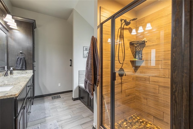 9908 SW 22nd St, Yukon, OK 73099 - full bathroom with tiled shower, double vanity, wood finished floors, and baseboards