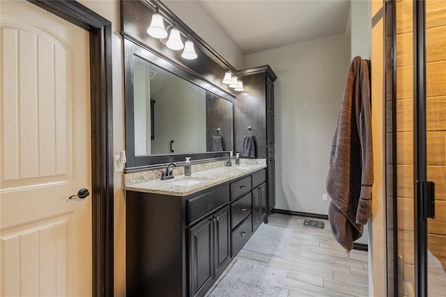 9908 SW 22nd St, Yukon, OK 73099 - bathroom with double vanity, baseboards, and wood finished floors