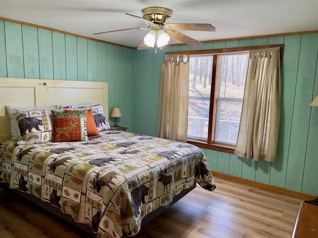 bedroom featuring wood finished floors, baseboards, and a ceiling fan