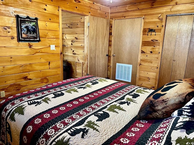 bedroom with wooden walls and visible vents
