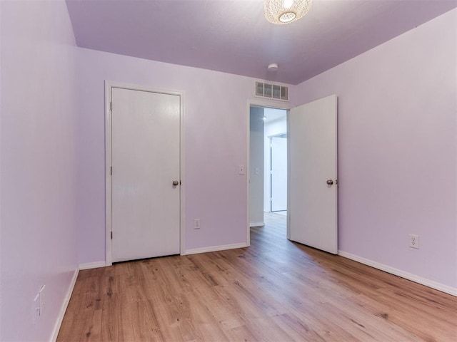 1801 NW 145th St, Edmond, OK 73013 - unfurnished bedroom with baseboards, wood finished floors, and visible vents