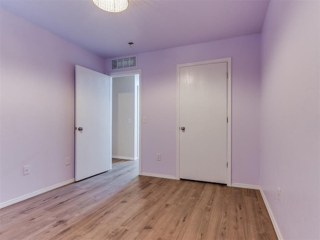 1801 NW 145th St, Edmond, OK 73013 - unfurnished bedroom with baseboards, wood finished floors, and visible vents