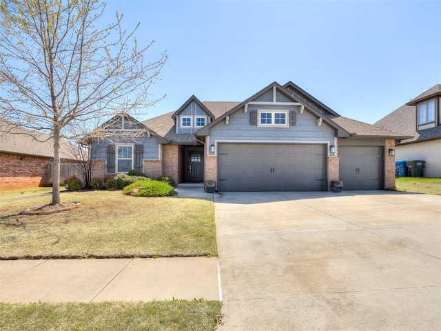 craftsman inspired home with brick siding, an attached garage, driveway, and a front lawn