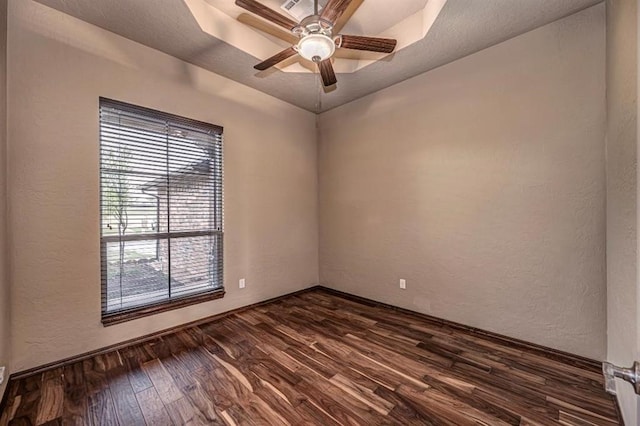 9609 Lakecrest Dr, Oklahoma City, OK 73159 - empty room featuring dark wood-style flooring, ceiling fan, a raised ceiling, and a textured wall