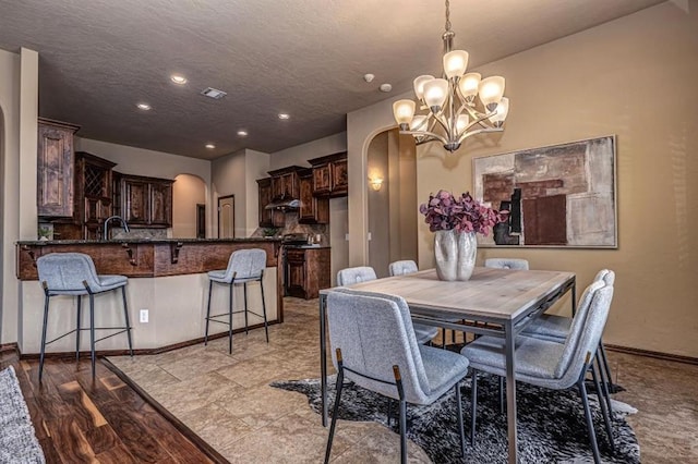 9609 Lakecrest Dr, Oklahoma City, OK 73159 - dining room with visible vents, arched walkways, an inviting chandelier, and a textured ceiling