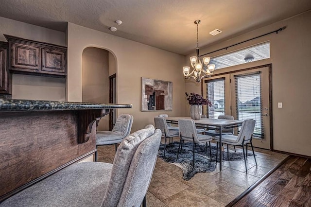9609 Lakecrest Dr, Oklahoma City, OK 73159 - dining room with arched walkways, a notable chandelier, visible vents, and a textured ceiling