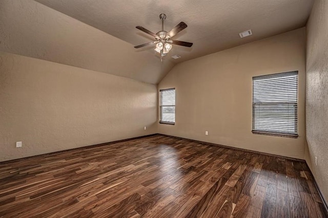 9609 Lakecrest Dr, Oklahoma City, OK 73159 - spare room featuring a textured wall, dark wood-type flooring, visible vents, lofted ceiling, and ceiling fan