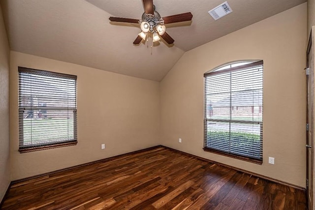 9609 Lakecrest Dr, Oklahoma City, OK 73159 - empty room with dark wood-style flooring, visible vents, plenty of natural light, and vaulted ceiling