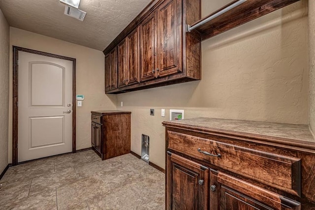 9609 Lakecrest Dr, Oklahoma City, OK 73159 - laundry area featuring hookup for a washing machine, a textured ceiling, visible vents, hookup for an electric dryer, and cabinet space