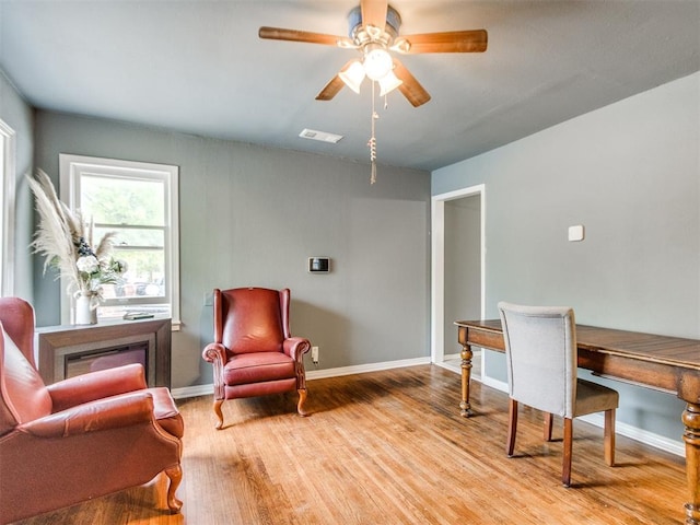 home office with baseboards, light wood-style flooring, visible vents, and a ceiling fan