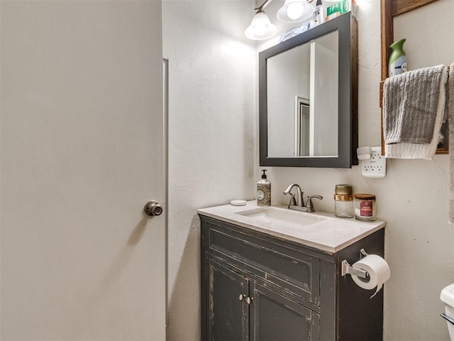 half bathroom with vanity and toilet