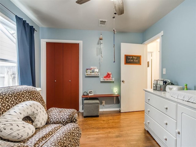 sitting room with baseboards, a ceiling fan, visible vents, and light wood-type flooring