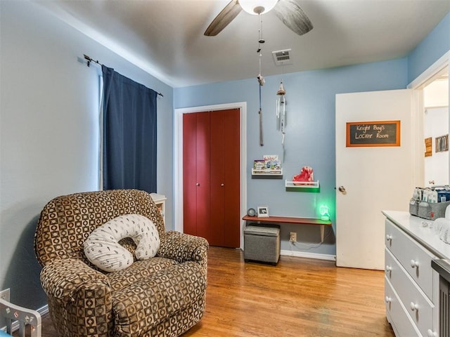 sitting room with ceiling fan, baseboards, light wood finished floors, and visible vents