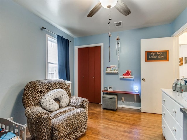 living area featuring light wood finished floors, baseboards, visible vents, and ceiling fan
