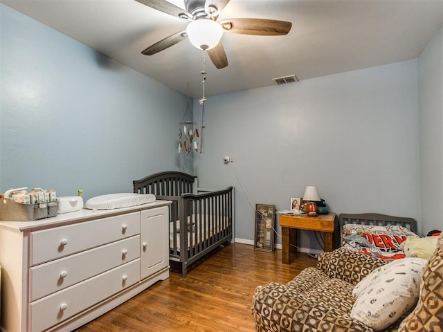 bedroom featuring wood finished floors, visible vents, and a ceiling fan