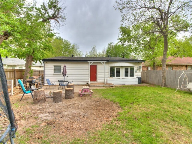 rear view of house with a lawn, a fenced backyard, and a patio area