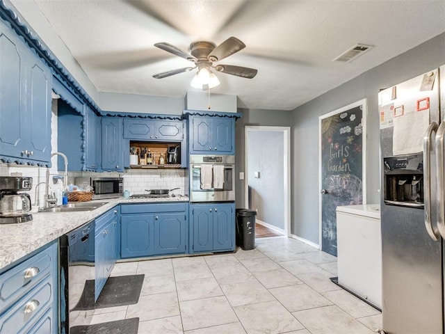 kitchen with a ceiling fan, a sink, blue cabinets, light countertops, and appliances with stainless steel finishes
