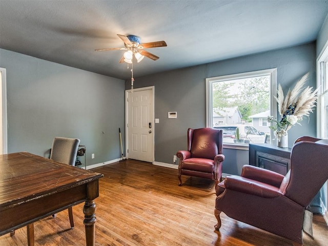 office space featuring baseboards, a ceiling fan, and wood finished floors