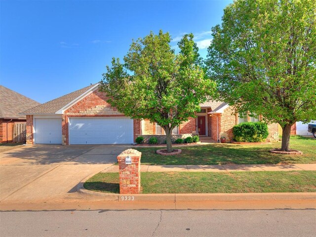 9333 SW 22nd St, Oklahoma City, OK 73128 - view of property hidden behind natural elements with a garage, brick siding, a front lawn, and driveway