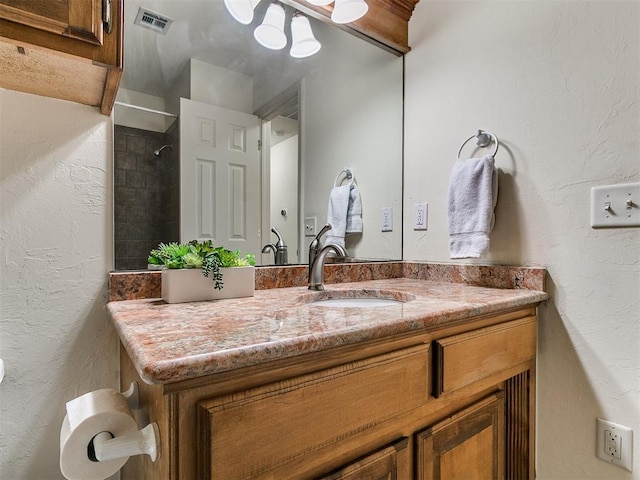 9333 SW 22nd St, Oklahoma City, OK 73128 - full bathroom with a tile shower, a textured wall, visible vents, and vanity