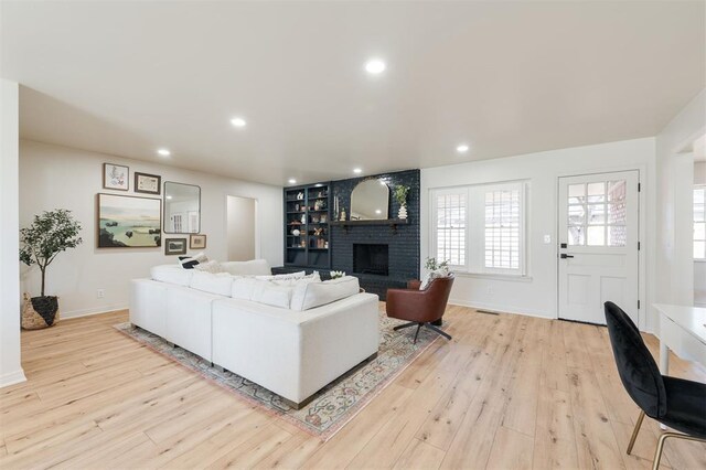 2501 NW 121st St, Oklahoma City, OK 73120 - living room featuring a brick fireplace, light wood finished floors, recessed lighting, and built in shelves