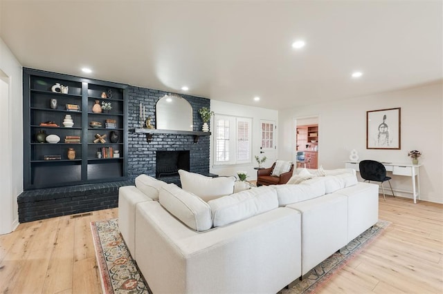 2501 NW 121st St, Oklahoma City, OK 73120 - living room featuring light wood finished floors, recessed lighting, a brick fireplace, and built in features