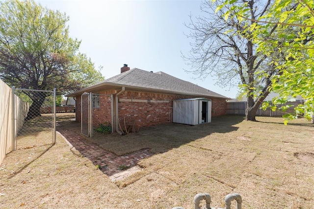 2501 NW 121st St, Oklahoma City, OK 73120 - back of property with brick siding, a fenced backyard, a chimney, and a storage unit