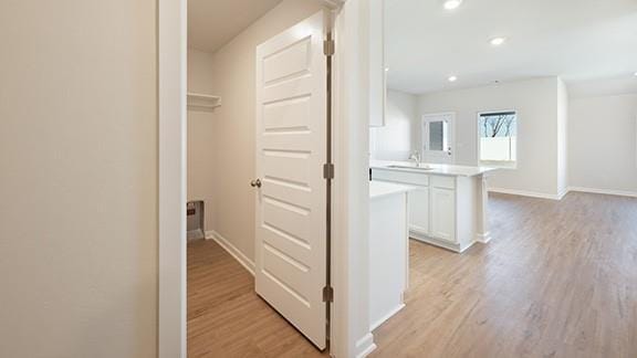 1209 E Stetson Ln, Mustang, OK 73064 - hallway featuring recessed lighting, light wood-style floors, baseboards, and a sink