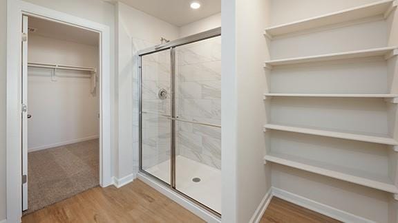 1209 E Stetson Ln, Mustang, OK 73064 - bathroom with a shower stall, wood finished floors, baseboards, and a spacious closet