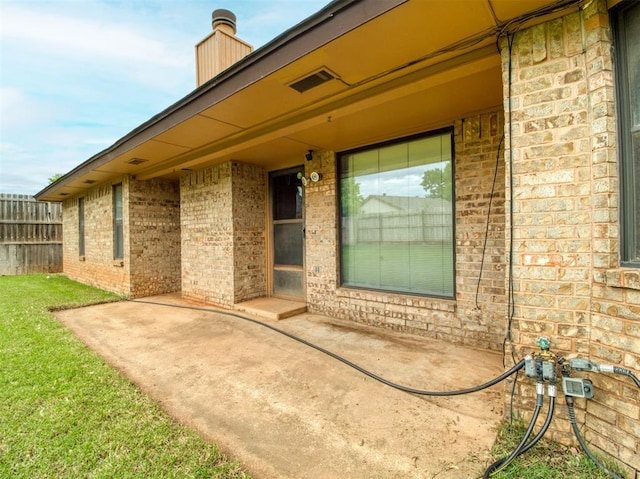1520 NE 2nd St, Moore, OK 73160 - property entrance with a patio, brick siding, and fence