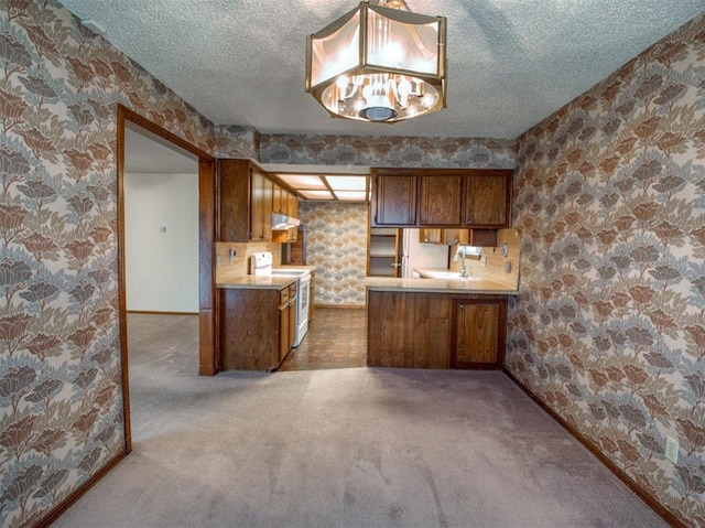 1520 NE 2nd St, Moore, OK 73160 - kitchen with brown cabinets, white electric stove, wallpapered walls, and a textured ceiling