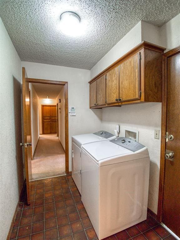 1520 NE 2nd St, Moore, OK 73160 - clothes washing area featuring washing machine and dryer, dark tile patterned flooring, a textured ceiling, and cabinet space