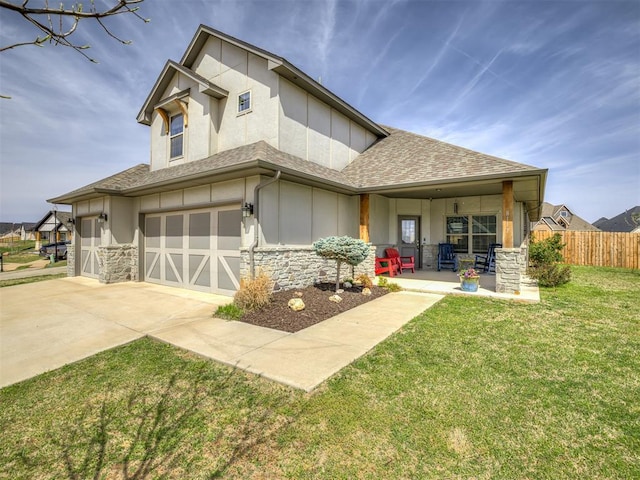 view of front of house featuring roof with shingles, fence, a front lawn, an attached garage, and concrete driveway