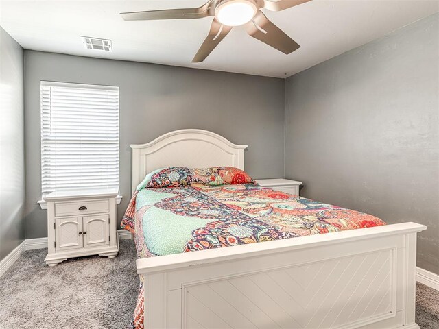 carpeted bedroom with visible vents, baseboards, and a ceiling fan