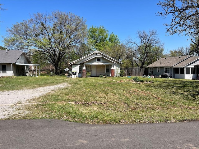 707 W Washington St, Tecumseh, OK 74873 - view of front facade featuring a sunroom, driveway, fence, and a front lawn