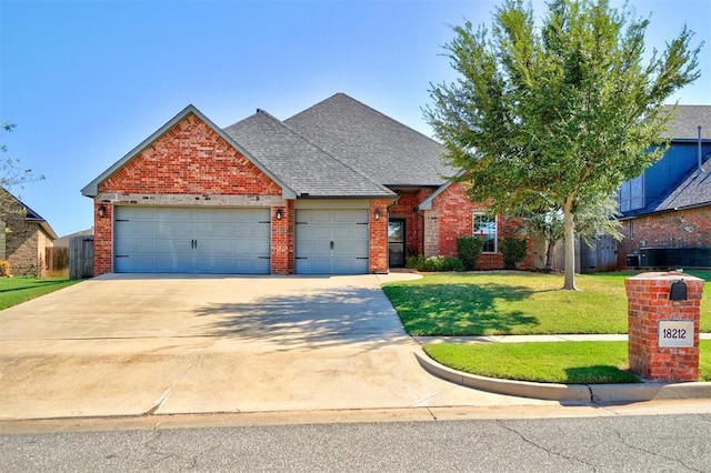 traditional-style house featuring concrete driveway, a front lawn, brick siding, a garage, and a shingled roof