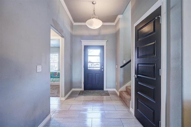 entryway with crown molding, baseboards, and stairway