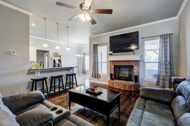 living room with wood finished floors, a fireplace, crown molding, and ceiling fan