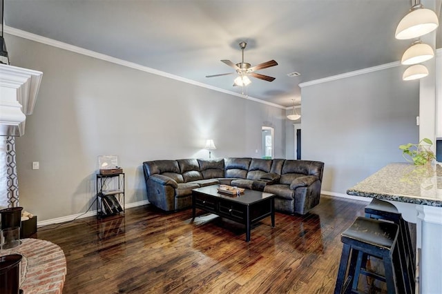 living area with baseboards, a ceiling fan, crown molding, and dark wood finished floors