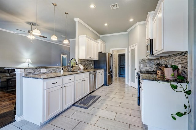 kitchen with visible vents, a sink, appliances with stainless steel finishes, a peninsula, and white cabinetry
