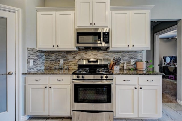 kitchen with white cabinets, dark stone countertops, decorative backsplash, and appliances with stainless steel finishes