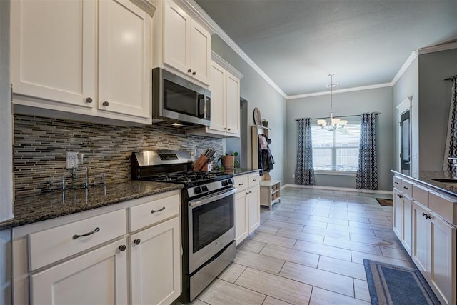 kitchen with a chandelier, white cabinetry, dark stone counters, decorative backsplash, and appliances with stainless steel finishes