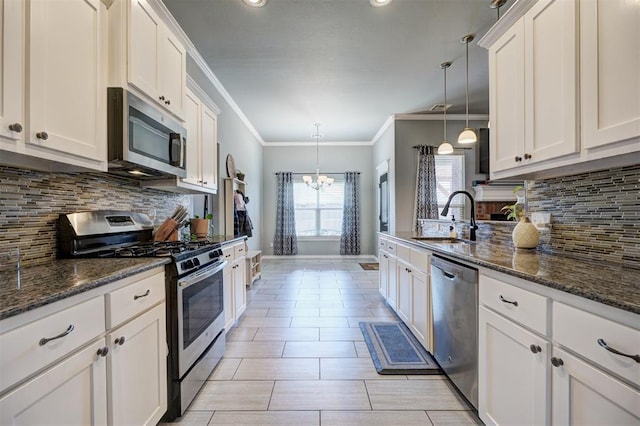 kitchen with decorative backsplash, a sink, white cabinetry, and stainless steel appliances