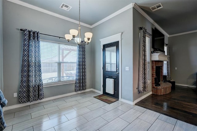 dining room with visible vents, wood finish floors, a notable chandelier, and a brick fireplace