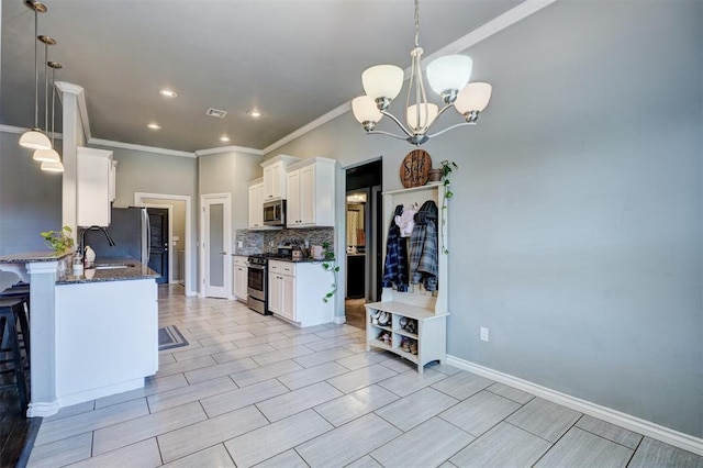 kitchen featuring dark stone countertops, a chandelier, white cabinets, decorative backsplash, and appliances with stainless steel finishes