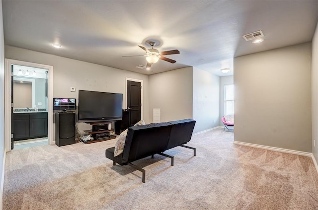 living room featuring light carpet, ceiling fan, baseboards, and visible vents