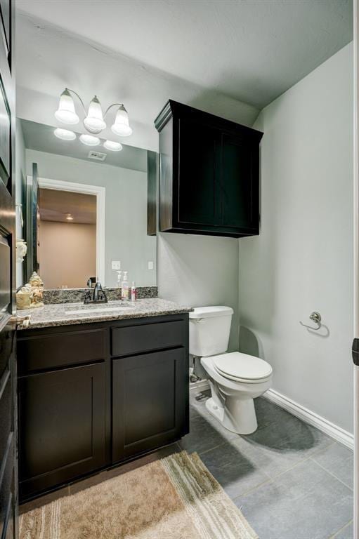 bathroom featuring vanity, baseboards, and toilet