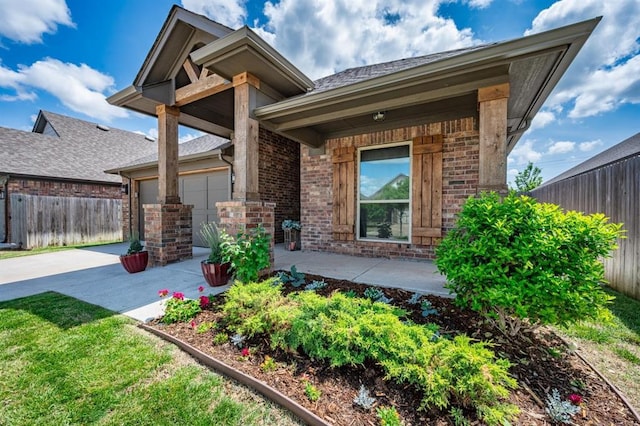 2420 NW 179th Ter, Edmond, OK 73012 - view of front facade with a garage, fence, a patio, brick siding, and concrete driveway